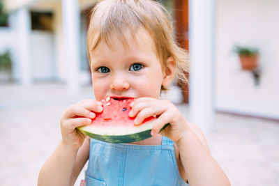 Portrait of cute girl eating slice of watermelon