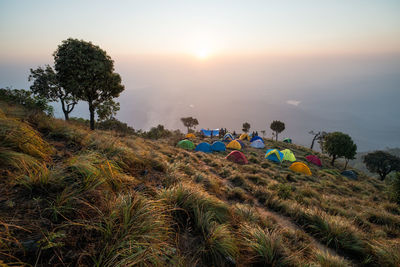 Tents on field against sky during sunset