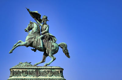 Low angle view of statue against clear blue sky