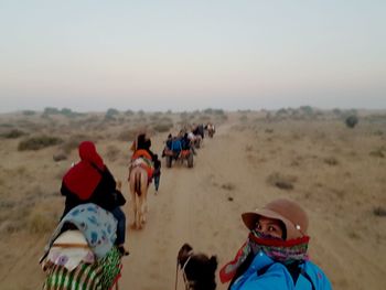 Group of people riding motorcycle on desert