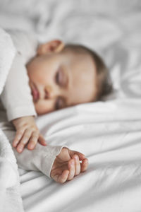 Close-up of cute baby boy lying on bed at home