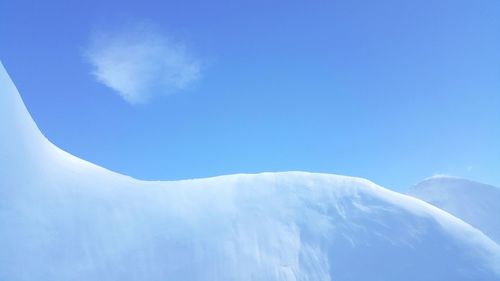 Low angle view of snow against clear blue sky