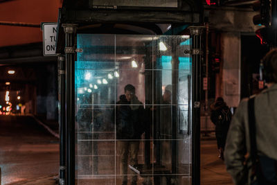 Reflection of man on glass window at night