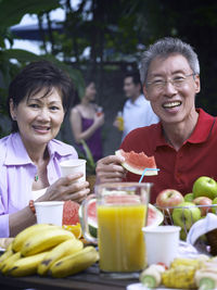 Portrait of smiling couple enjoying breakfast at restaurant