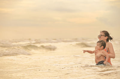 Full length of young woman exercising at beach