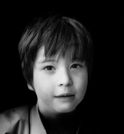 Close-up portrait of cute boy in dark