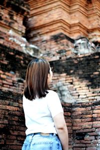 Rear view of woman standing against building