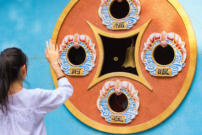 Rear view of woman standing against multi colored wall