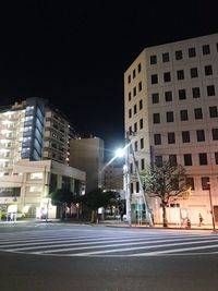 Illuminated buildings against sky at night