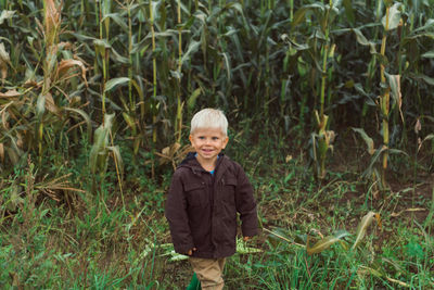 Cute happy child smiley face in corn field