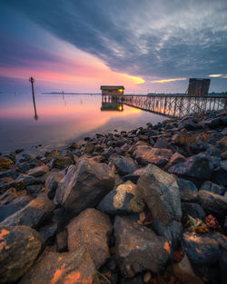 Bridge over sea against sky during sunset