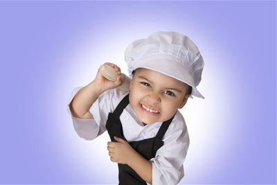 Portrait of smiling boy standing against white background