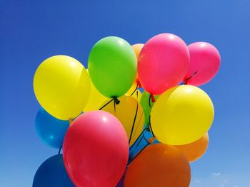 Low angle view of balloons against blue sky