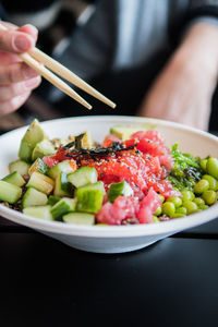 Midsection of person eating salad