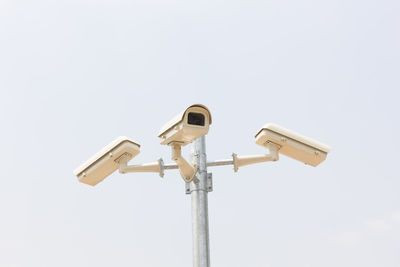 Low angle view of security camera against clear sky