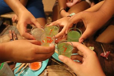 Cropped hands of friends toasting drink