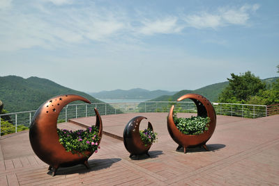 Potted plants on table by mountains against sky