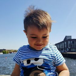 Portrait of smiling boy against river