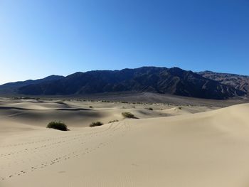 Scenic view of desert against clear blue sky