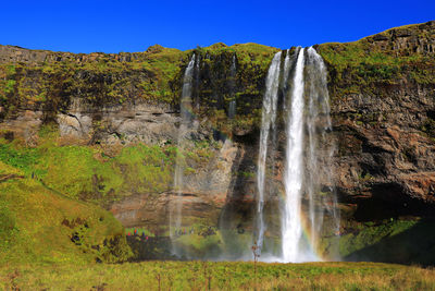 Scenic view of waterfall against sky
