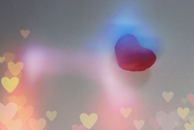 Defocused image of illuminated lights against sky