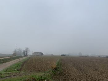 Scenic view of field against sky during foggy weather