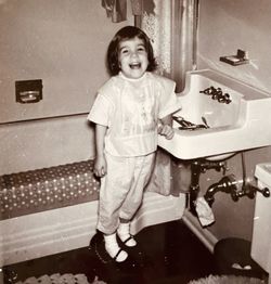 Portrait of smiling girl standing in bathroom