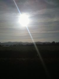 Sunlight streaming on field against bright sun