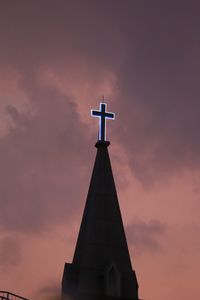 Low angle view of weather vane against sky