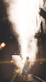 Rear view of man walking amidst buildings in city