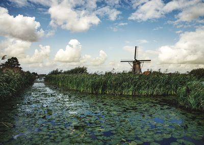 Traditional windmill on field against sky