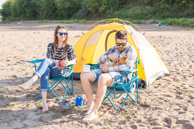 People sitting on swing at beach