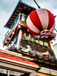 Low angle view of lanterns hanging on roof against building