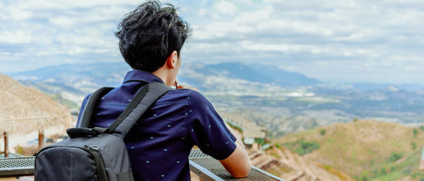 Rear view of man looking at landscape from observation point