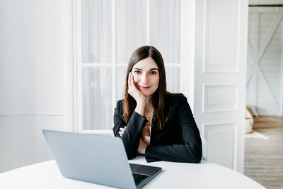 Portrait of a smiling young woman using phone