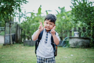 Cute boy standing against plants