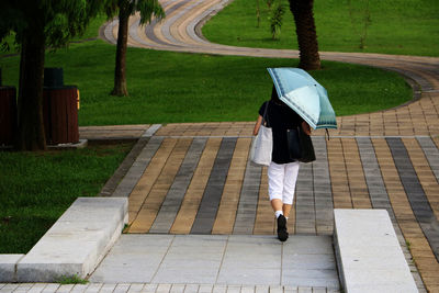 Rear view of woman walking on footpath