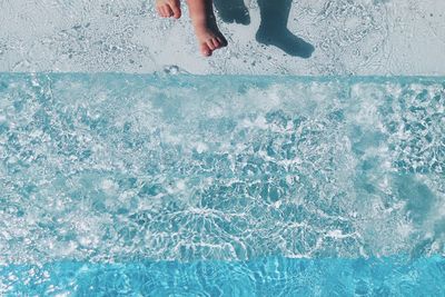 Low section of person swimming in pool