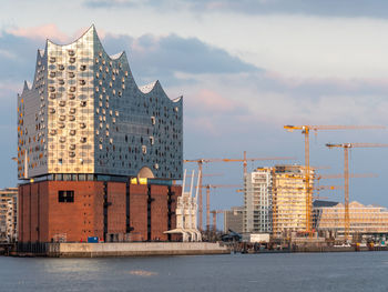 Buildings by sea against sky in city