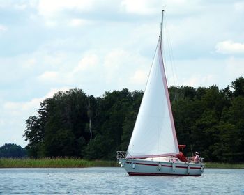 Sailboat sailing on lake against sky