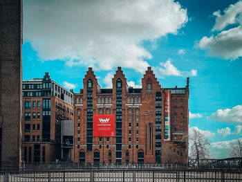 Low angle view of buildings against cloudy sky