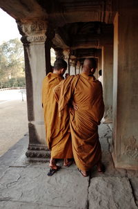 Rear view of monks standing in corridor at angkor wat