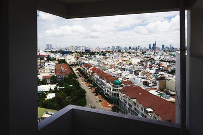 High angle view of buildings against sky seen through glass window