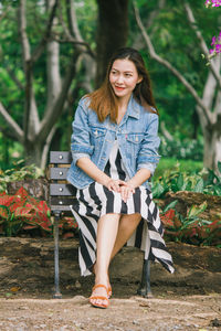 Portrait of smiling young woman sitting outdoors