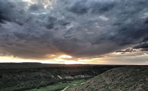 Scenic view of field against dramatic sky