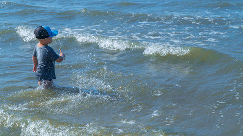 High angle view of boy enjoying in sea