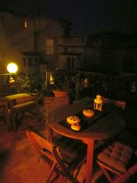 Illuminated table and chairs at night