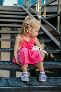 Portrait of young woman sitting on staircase