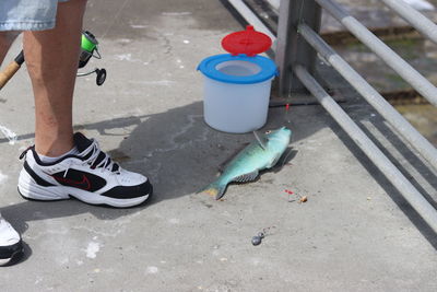 Low section of man with umbrella on footpath
