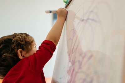 Boy drawing on whiteboard